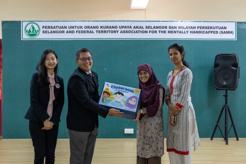 Chan Zi Tong and Dr Chua Ping Yong handing over the gathered of educational materials to SAMH Wisma Harapan